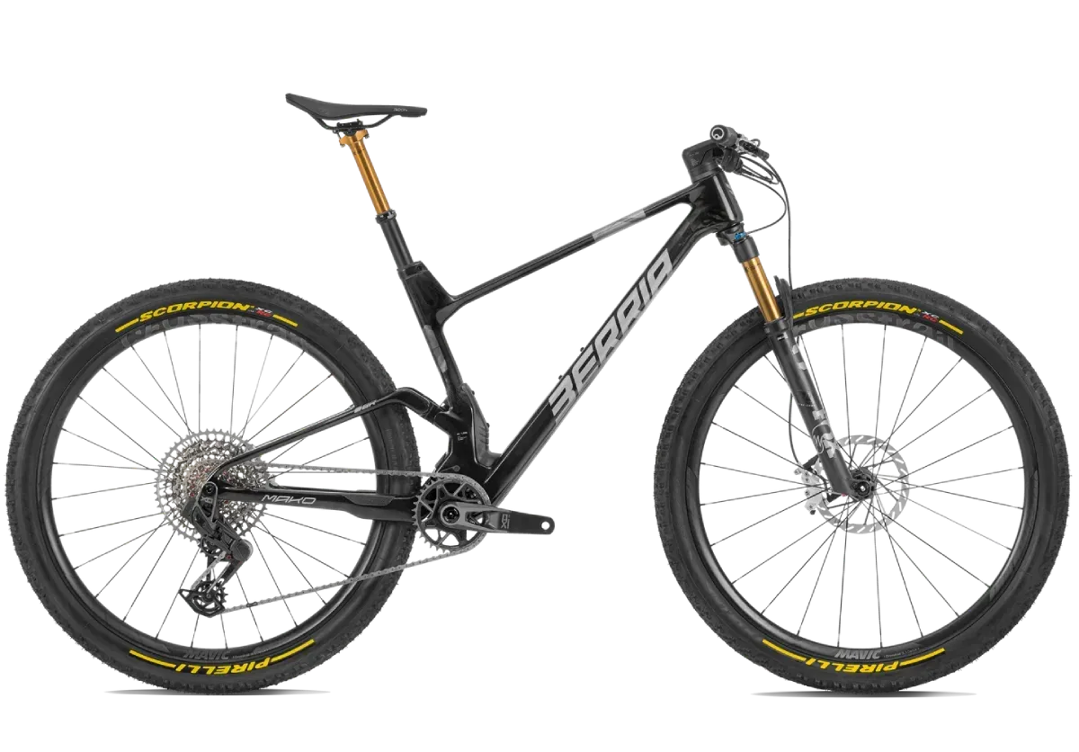 Bicicleta de montaña negra con detalles dorados y neumáticos amarillos.