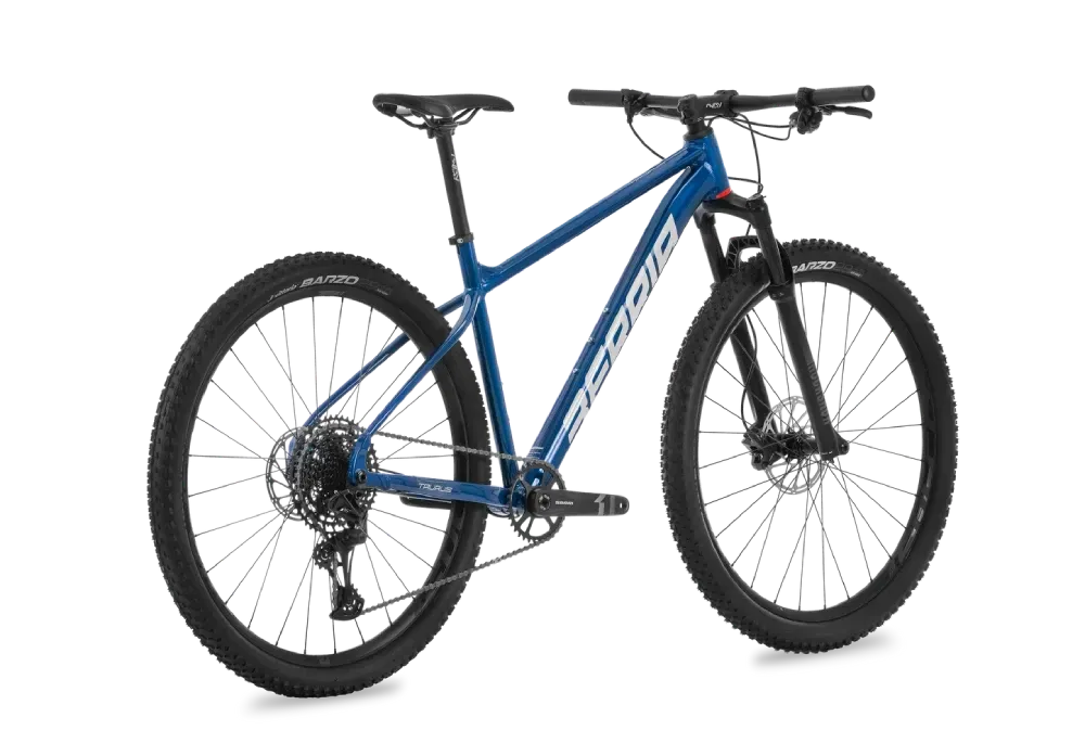 Bicicleta de montaña azul con neumáticos y componentes negros, en ángulo sobre un fondo blanco.