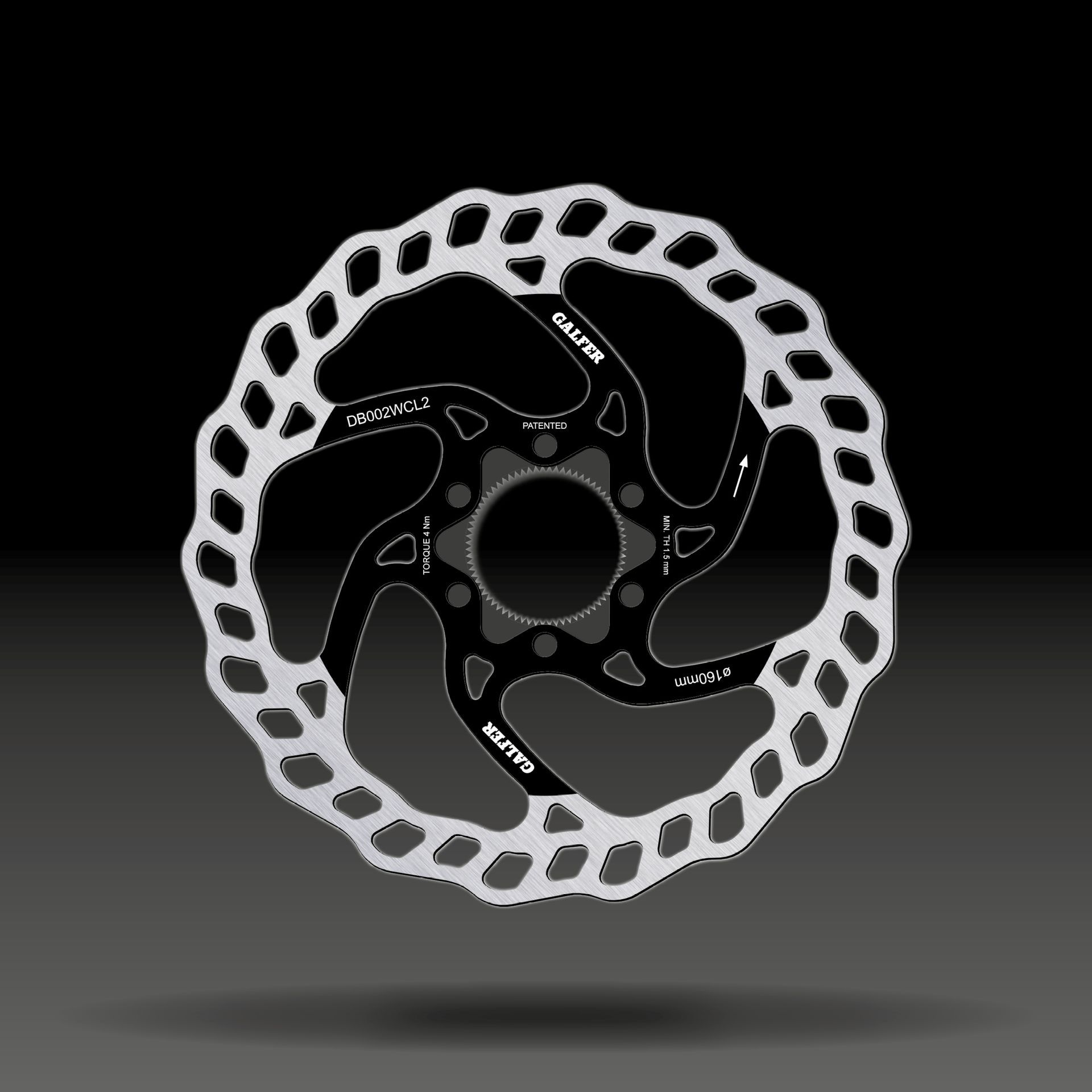 Rotor de freno de disco de bicicleta plateado y negro con un borde exterior ondulado, sobre un fondo oscuro.