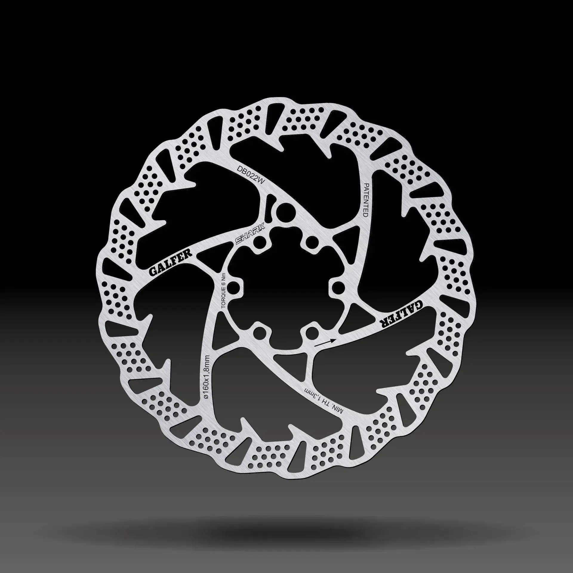 Rotor de freno de disco de bicicleta de montaña plateado con bordes ranurados y orificios para tornillos centrales.