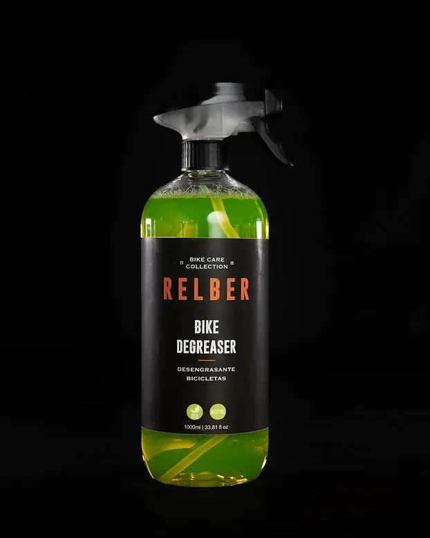 Botella de spray desengrasante para bicicletas de color verde, etiqueta negra, texto blanco y fondo negro.