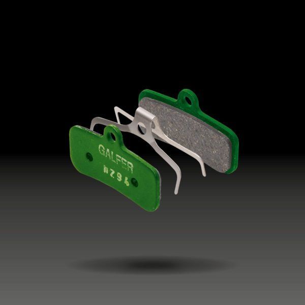 Pastillas de freno de disco para bicicleta Galfer de color verde, con clip de resorte y fondo negro.