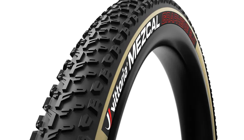 Neumático de bicicleta de montaña negro y beige sobre llanta oscura, texto