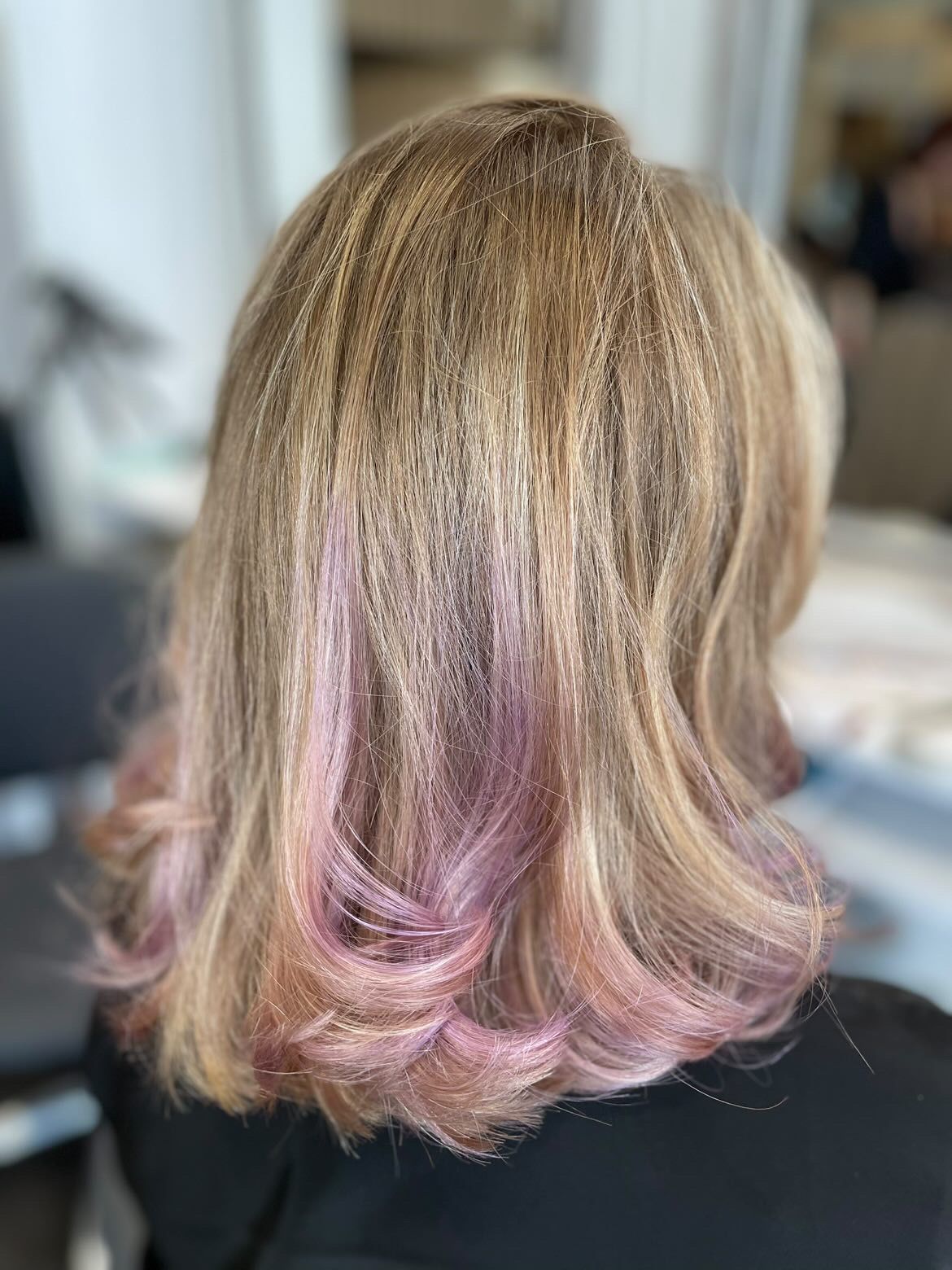 Gros plan sur une personne aux cheveux blonds courts. Les cheveux sont texturés et dégradés sur les côtés.