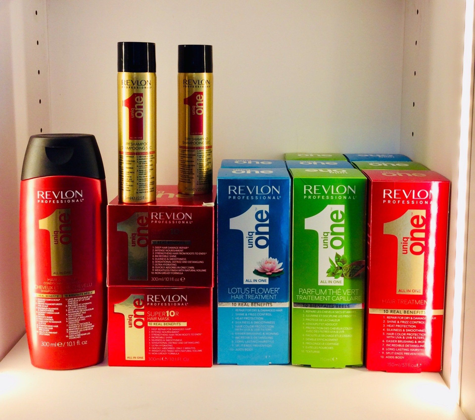 Des rangées de flacons de shampoing colorés sur une étagère, avec des bouchons argentés et des teintes variées comme le vert, l'orange et le violet.