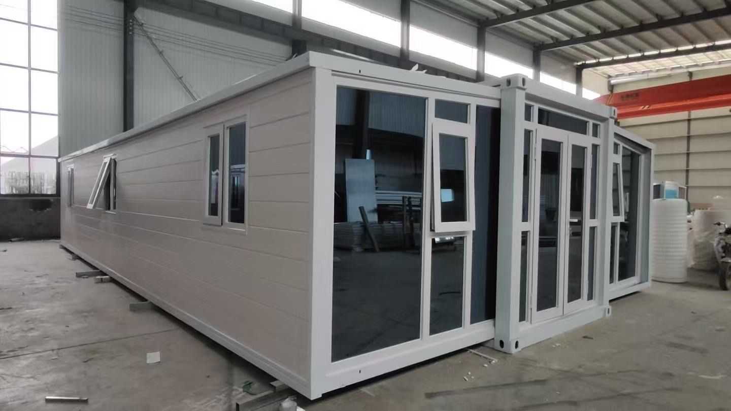 Edificio modular moderno con revestimiento blanco y grandes puertas de cristal en el interior de un almacén.