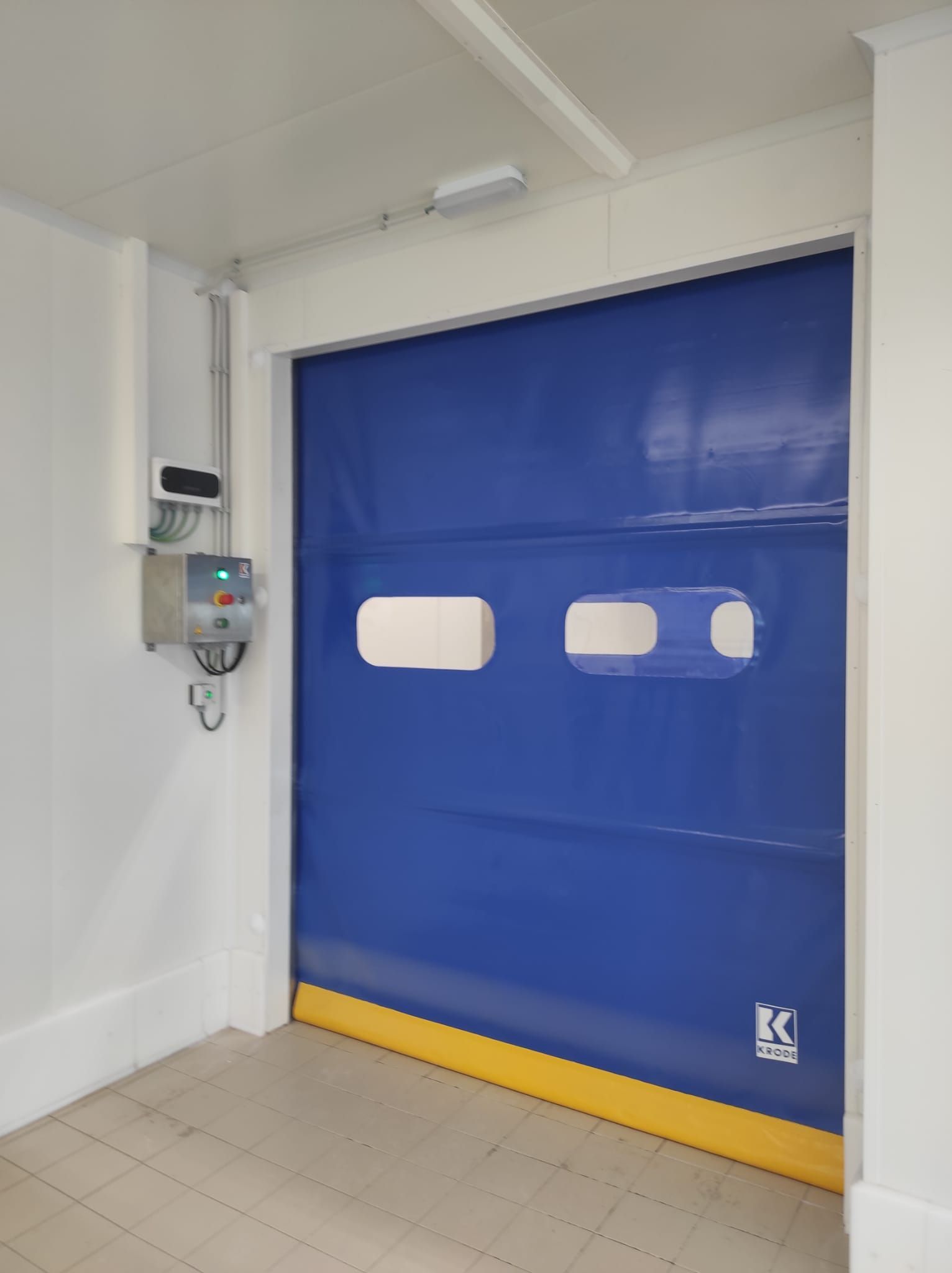 Una puerta azul está abierta en una habitación con una pared blanca.