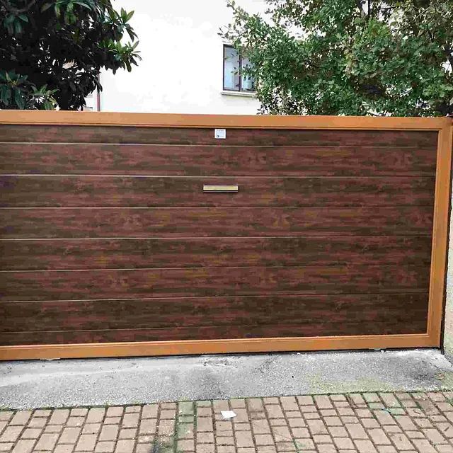 Una puerta de garaje de madera con un marco de madera se encuentra encima de un camino de entrada de ladrillos.