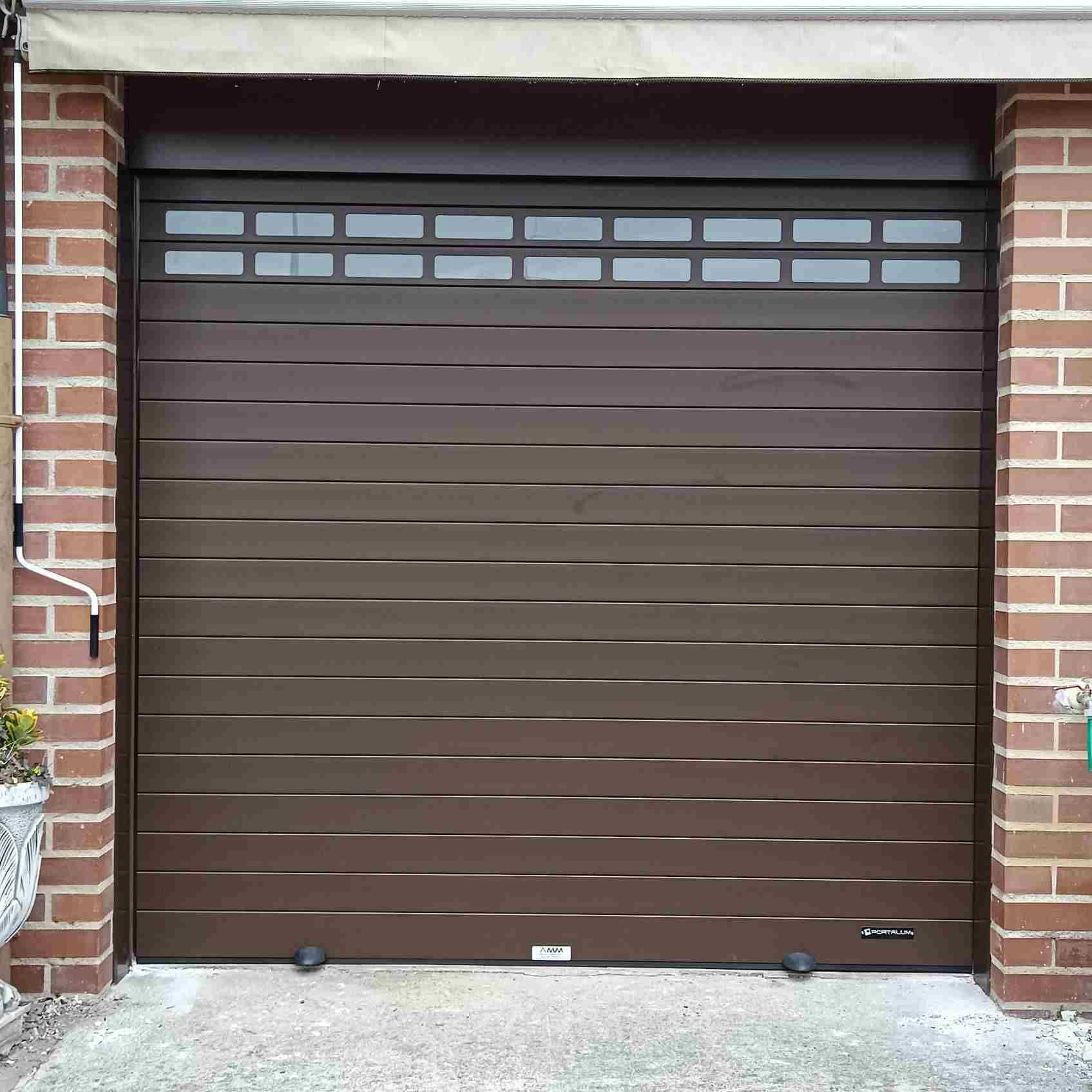 Una puerta de garaje marrón está frente a un edificio de ladrillos.