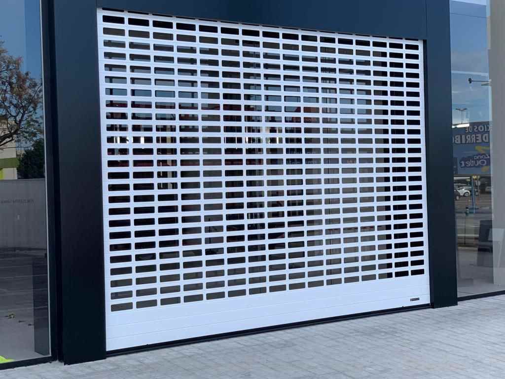 Una puerta de garaje blanca está situada al costado de un edificio.