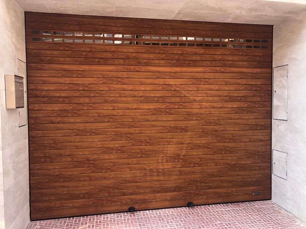 Una gran puerta de garaje de madera está abierta en un garaje.