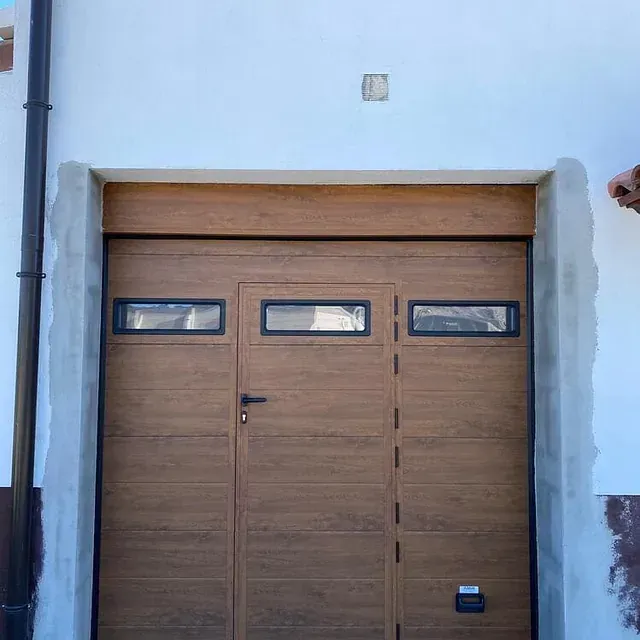 Una persona está parada frente a una puerta de garaje de madera.
