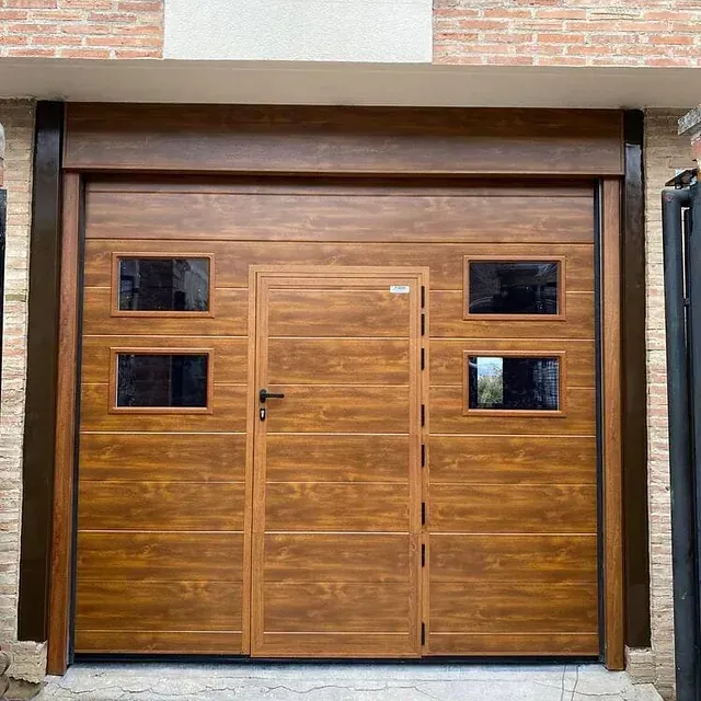 Una puerta de garaje de madera con una puerta y ventanas en un edificio de ladrillo.