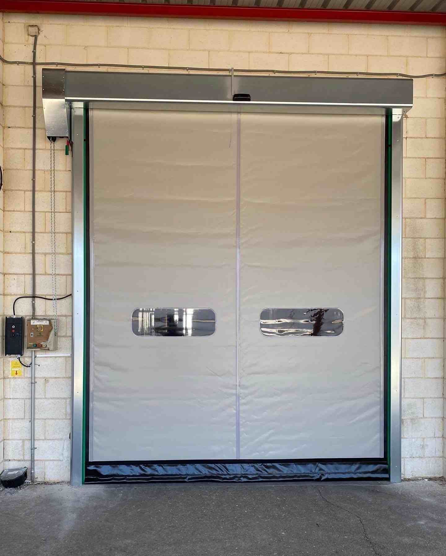 Una puerta blanca está abierta en un edificio de ladrillo.