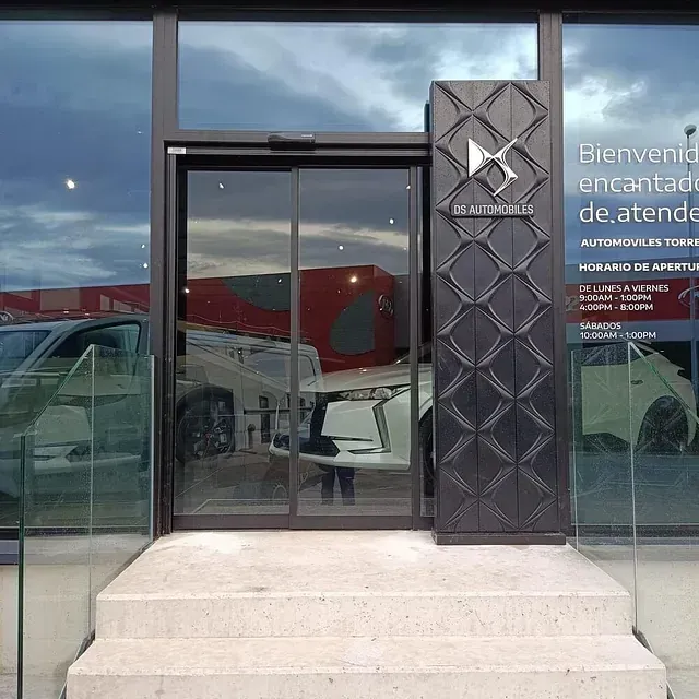 Un coche se refleja en el escaparate de un concesionario de coches.