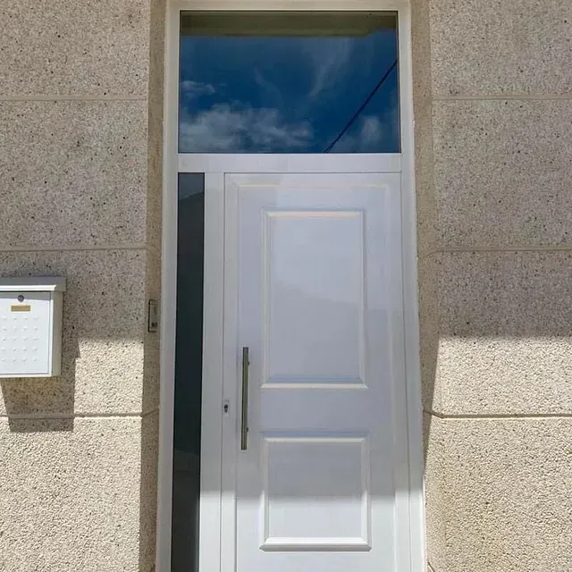 Una puerta blanca con una ventana de vidrio y un buzón en el costado de un edificio.
