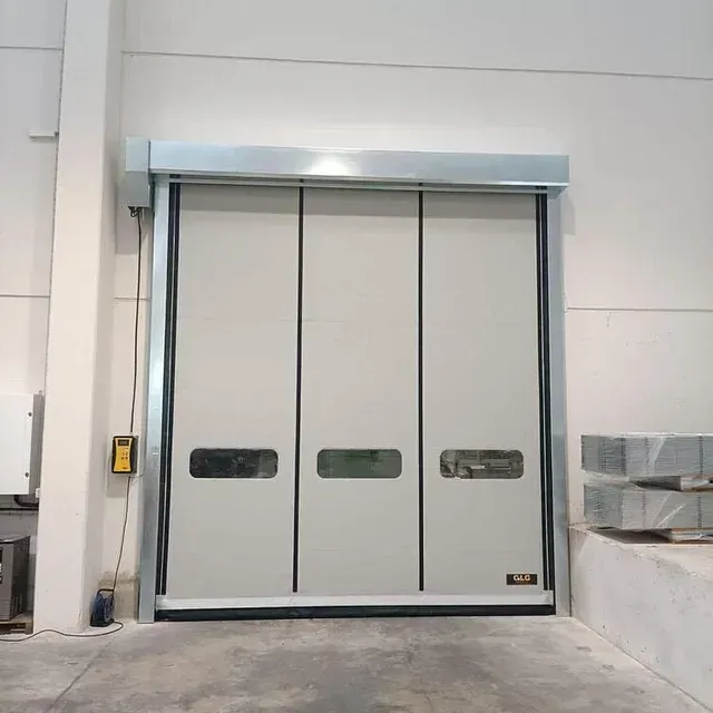 Una gran puerta blanca con un marco negro está en un almacén.