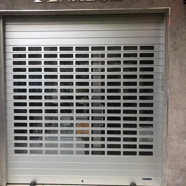 Una puerta de garaje enrollable plateada con agujeros.