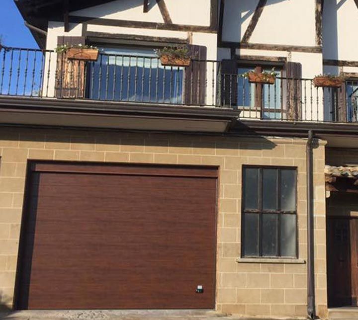 Una casa con balcón y puerta de garaje