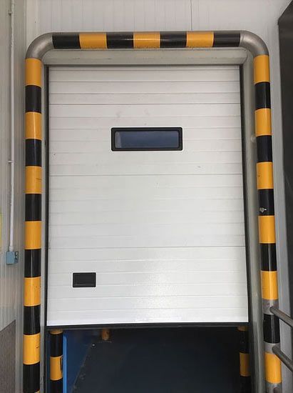 Una puerta blanca con rayas amarillas y negras alrededor.