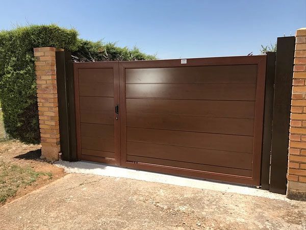 Una puerta marrón está al lado de una pared de ladrillos.