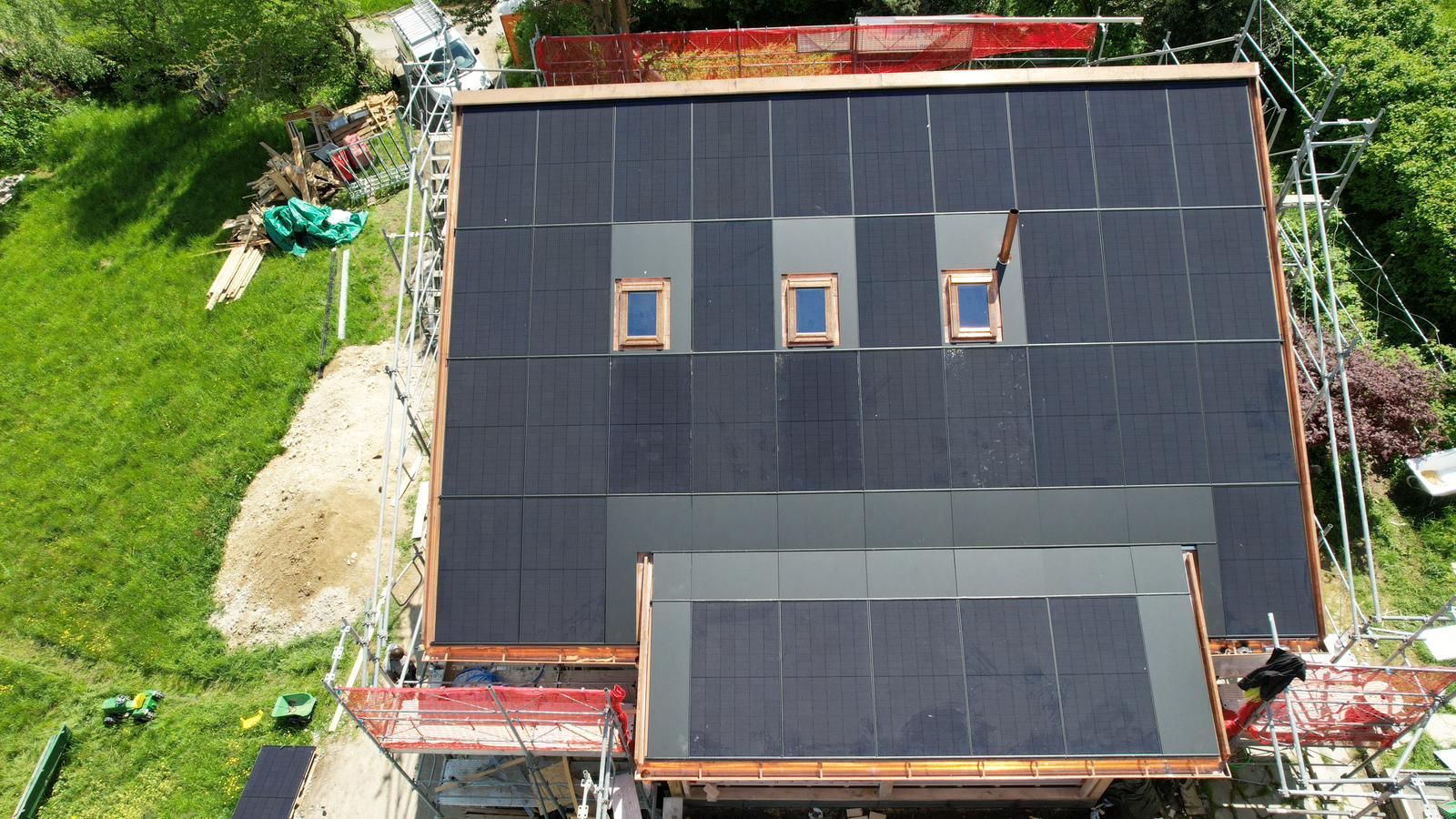 Eine Luftaufnahme eines Hauses mit Solarmodulen auf dem Dach.