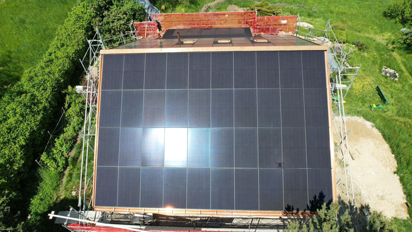 Eine Luftaufnahme eines Gebäudes mit Solarmodulen auf dem Dach.