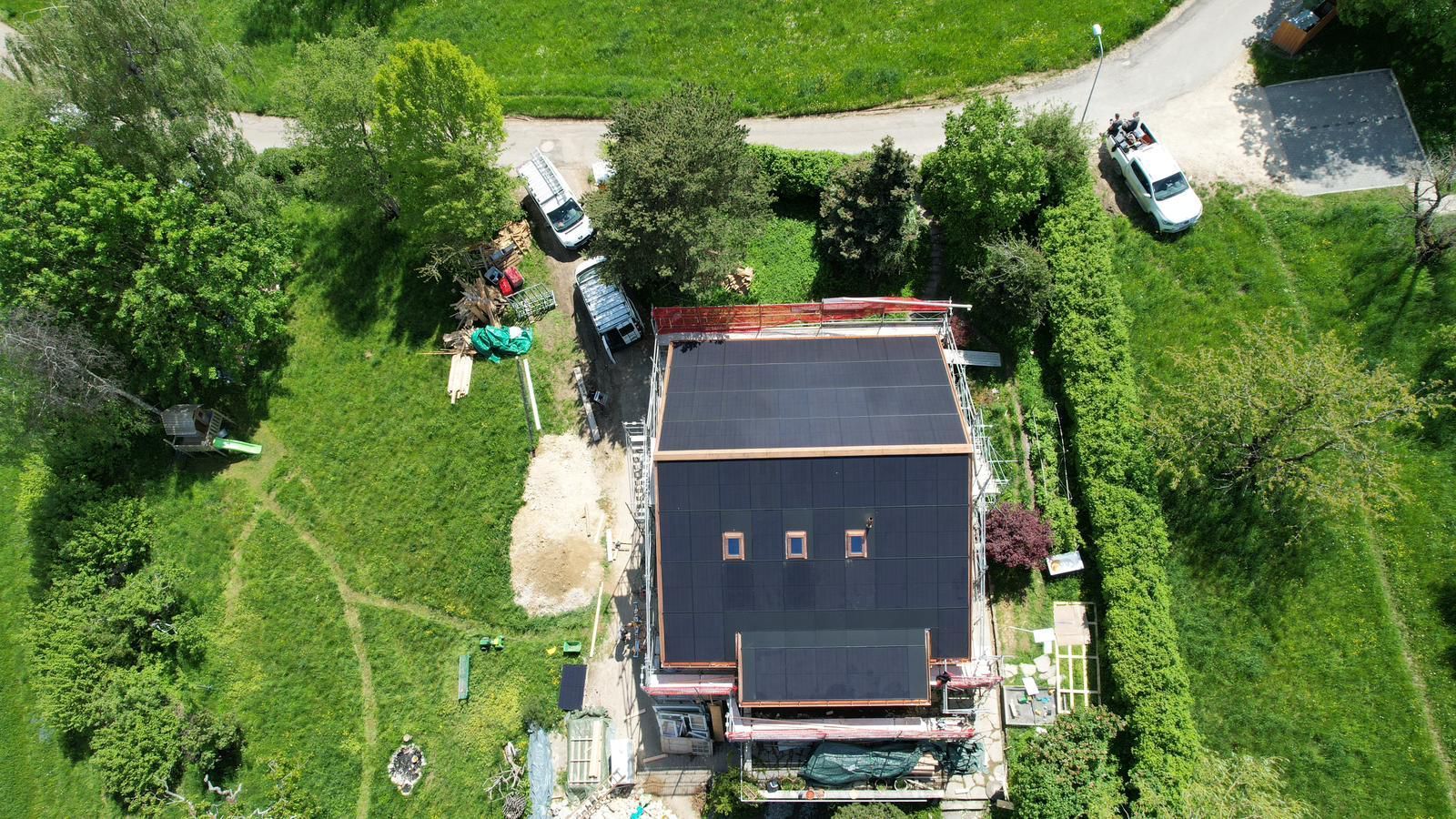 Eine Luftaufnahme eines Hauses mit Solarmodulen auf dem Dach.