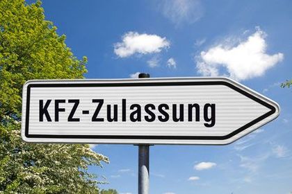 Ein weißes Schild mit einem nach rechts zeigenden schwarzen Pfeil weist auf die Kfz-Zulassung hin.