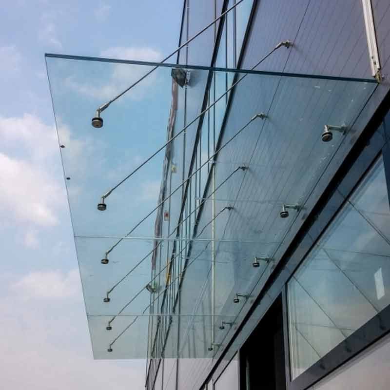 Milchglastür mit silbernem Griff in einem neutral getönten Flur mit weißen Zierleisten und Fenstern.