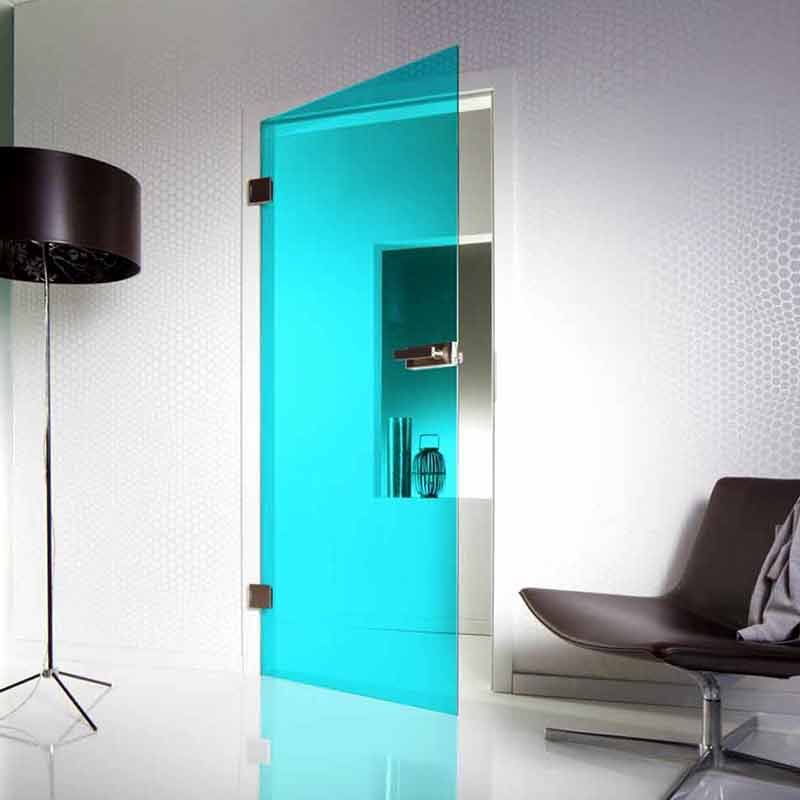 Milchglastür mit silbernem Griff in einem neutral getönten Flur mit weißen Zierleisten und Fenstern.