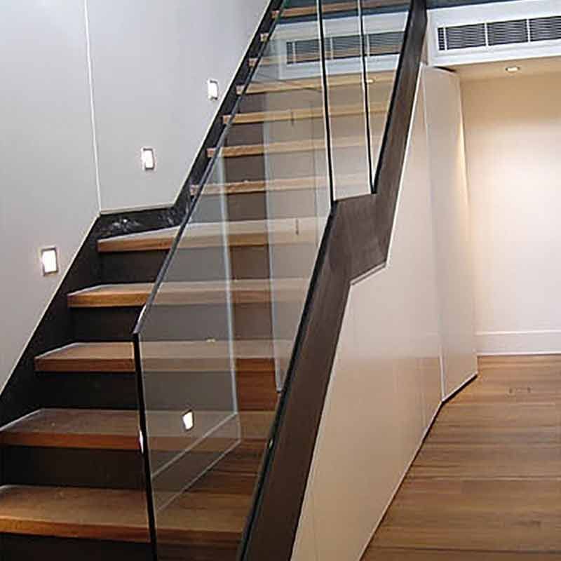 Glastreppe mit Glasstufen und Metallhandläufen.