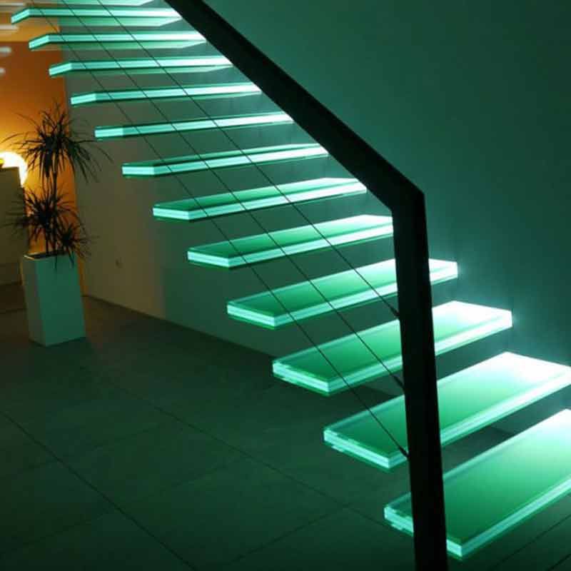 Milchglastür mit silbernem Griff in einem neutral getönten Flur mit weißen Zierleisten und Fenstern.