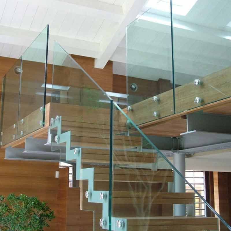 Eine große rote Tür steht einen Spalt breit offen und spiegelt Bambus. Die Tür hat einen langen, silbernen Griff.