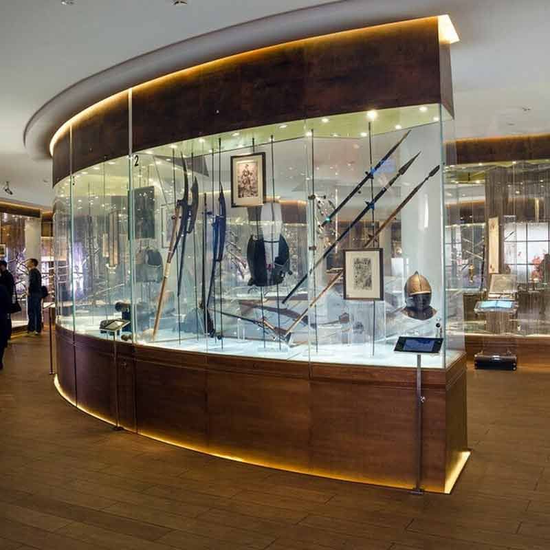 Eine große rote Tür steht einen Spalt breit offen und spiegelt Bambus. Die Tür hat einen langen, silbernen Griff.