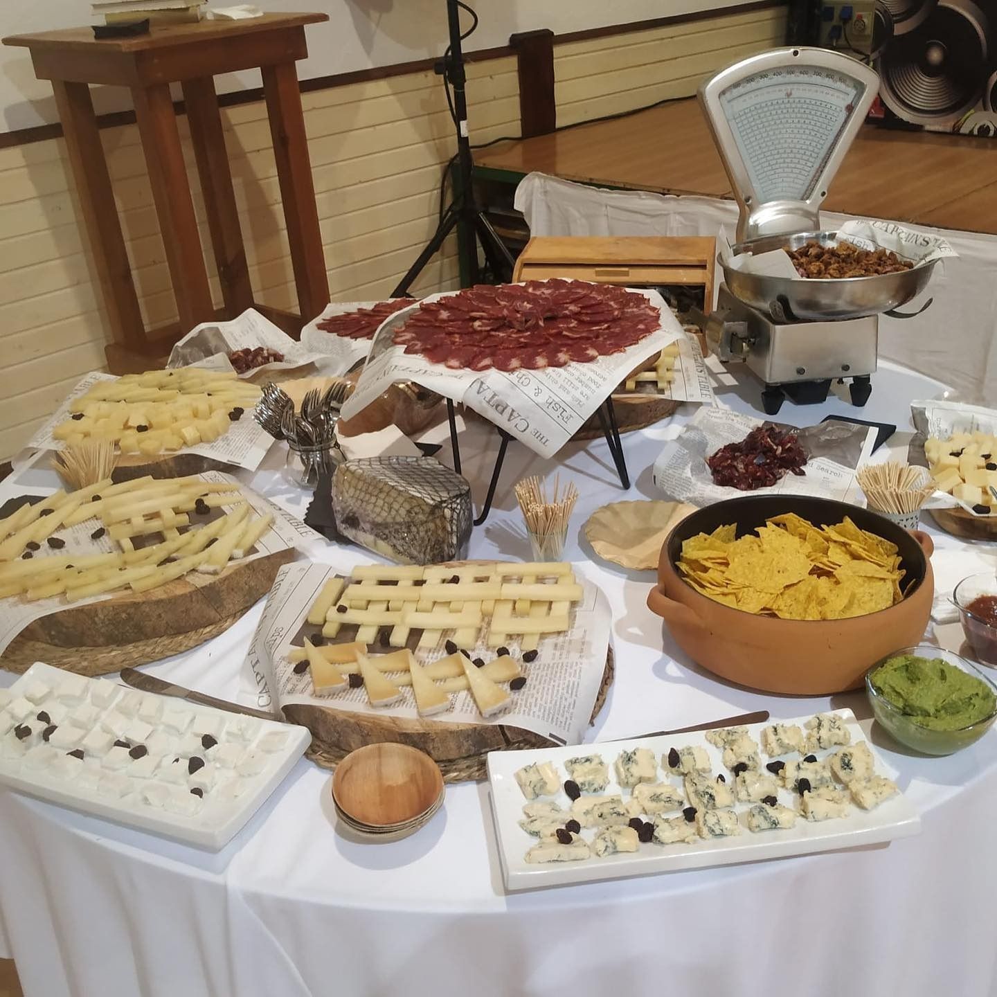 Una mesa con mucha comida y una báscula sobre ella.