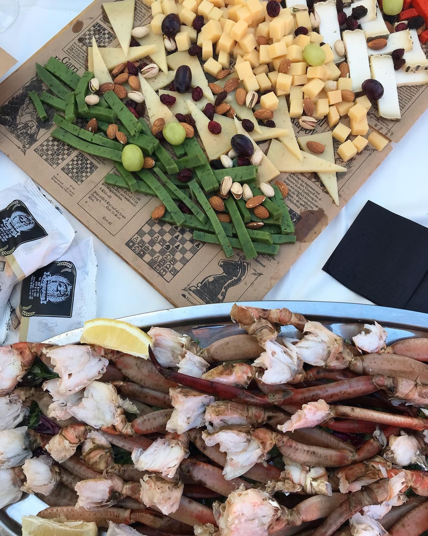 Una mesa cubierta con platos de comida que incluían patas de cangrejo y queso.