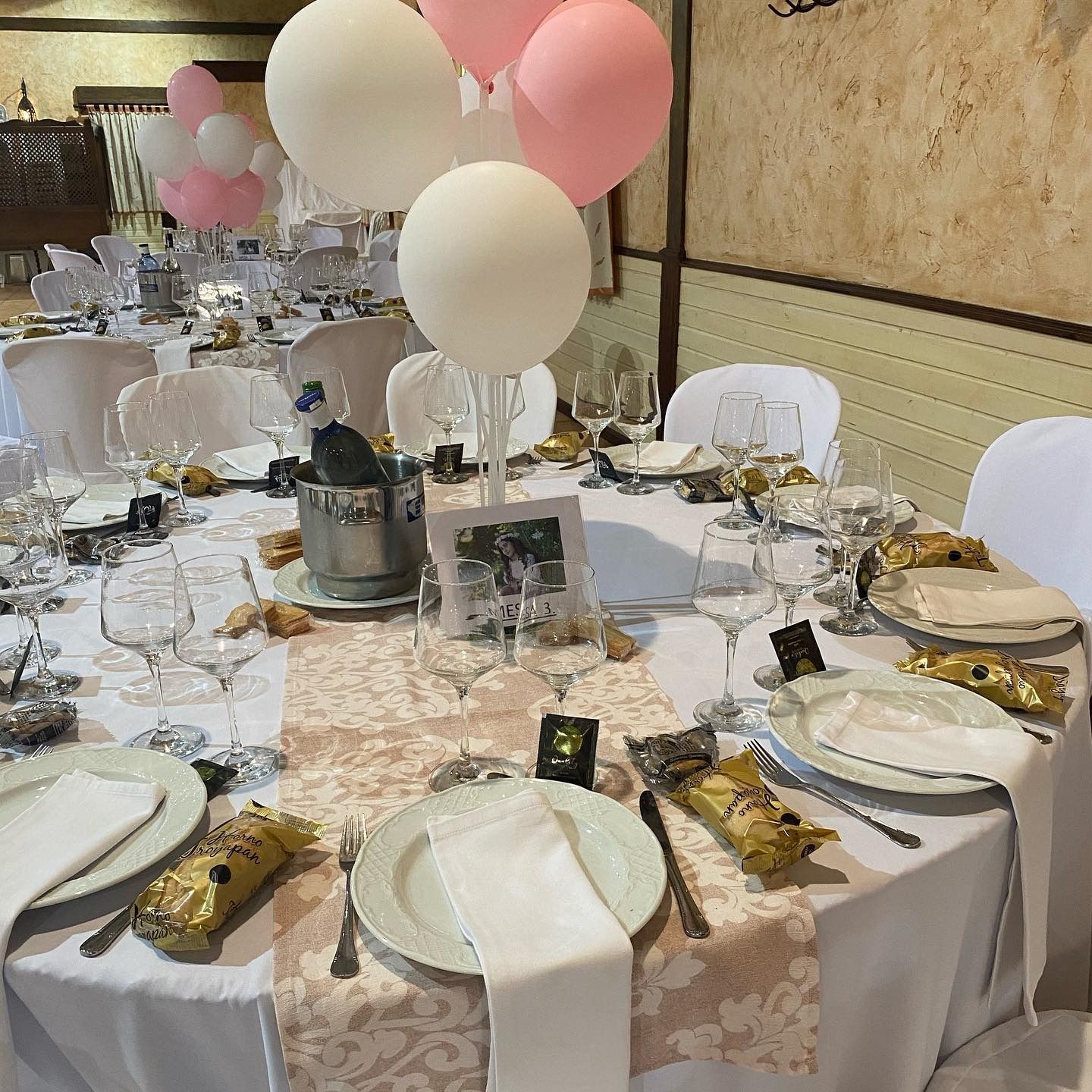 Una mesa con platos, vasos y globos encima.