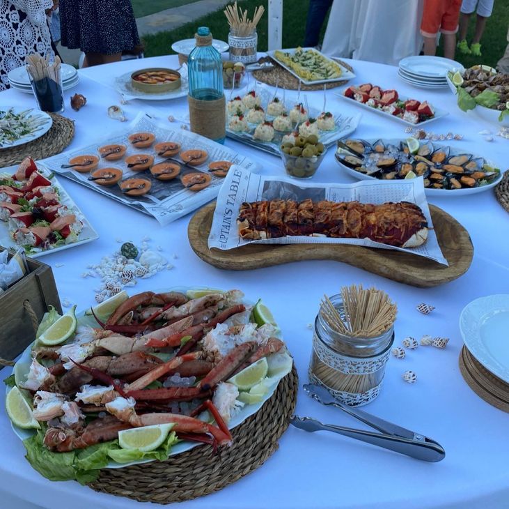 Una mesa llena de una variedad de alimentos, incluidas patas de cangrejo.