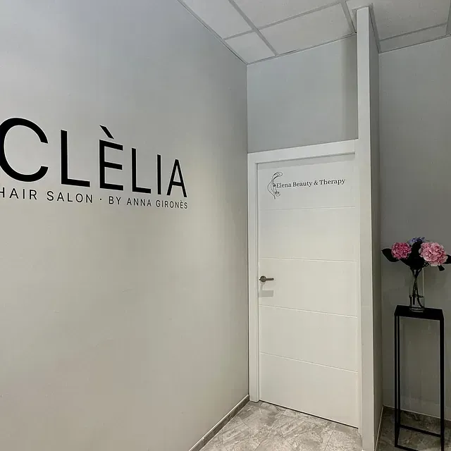 Una peluquería con un cartel en la pared y una puerta.