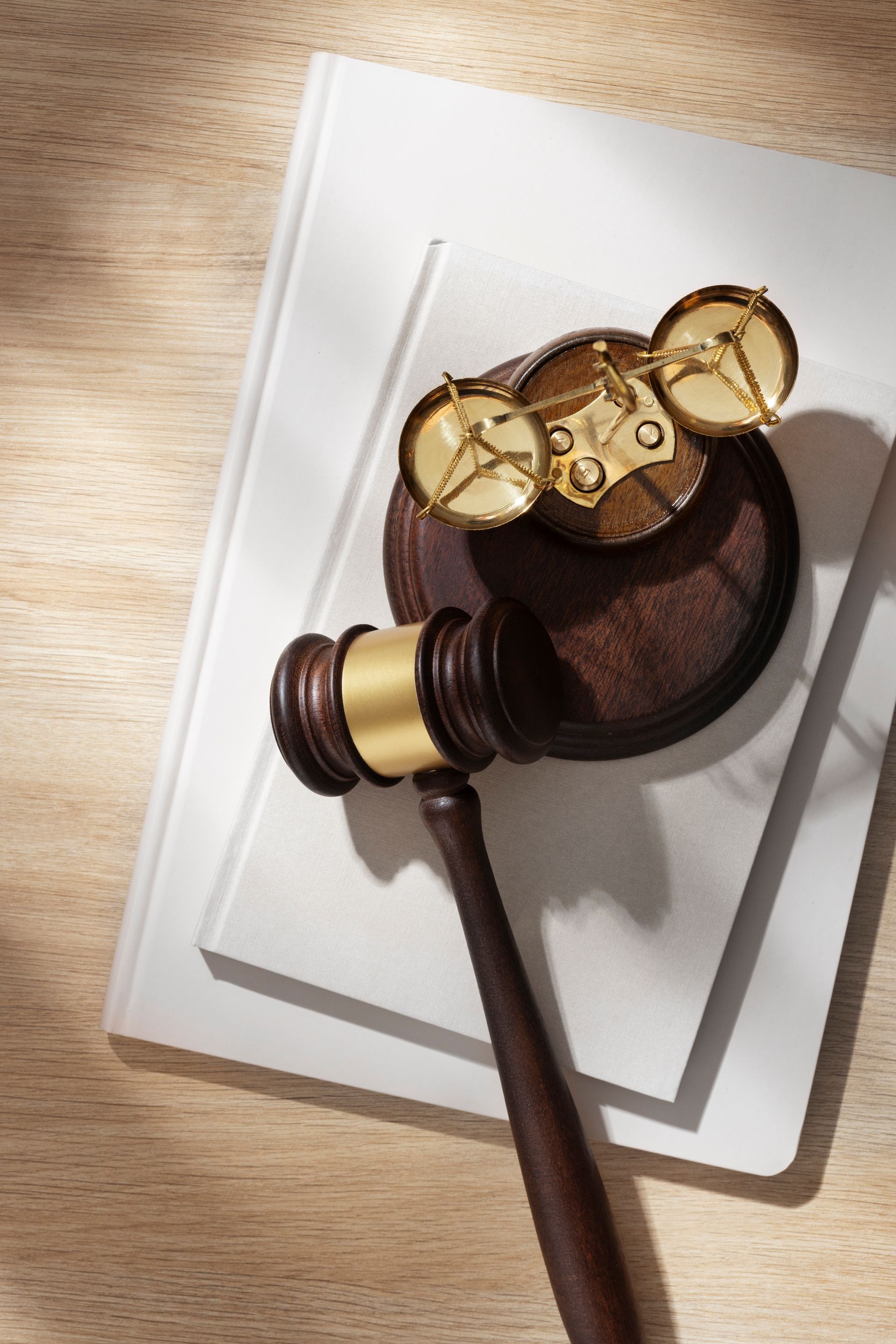 Un mazo de juez de madera reposa encima de un libro blanco.