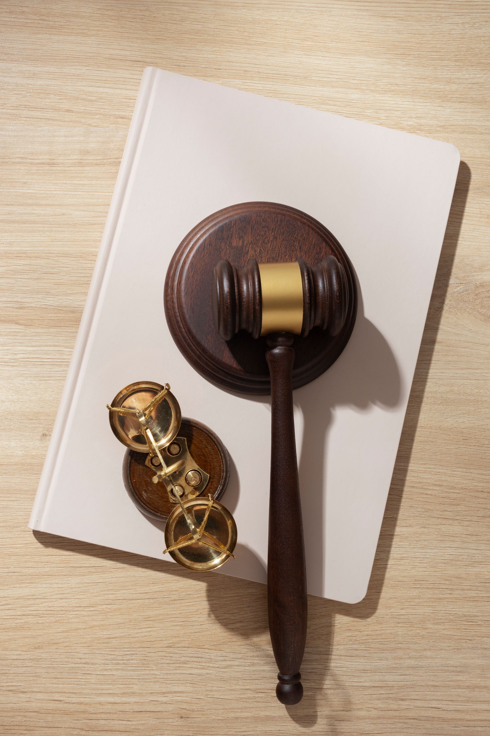 Un mazo de juez de madera está sobre un libro blanco.