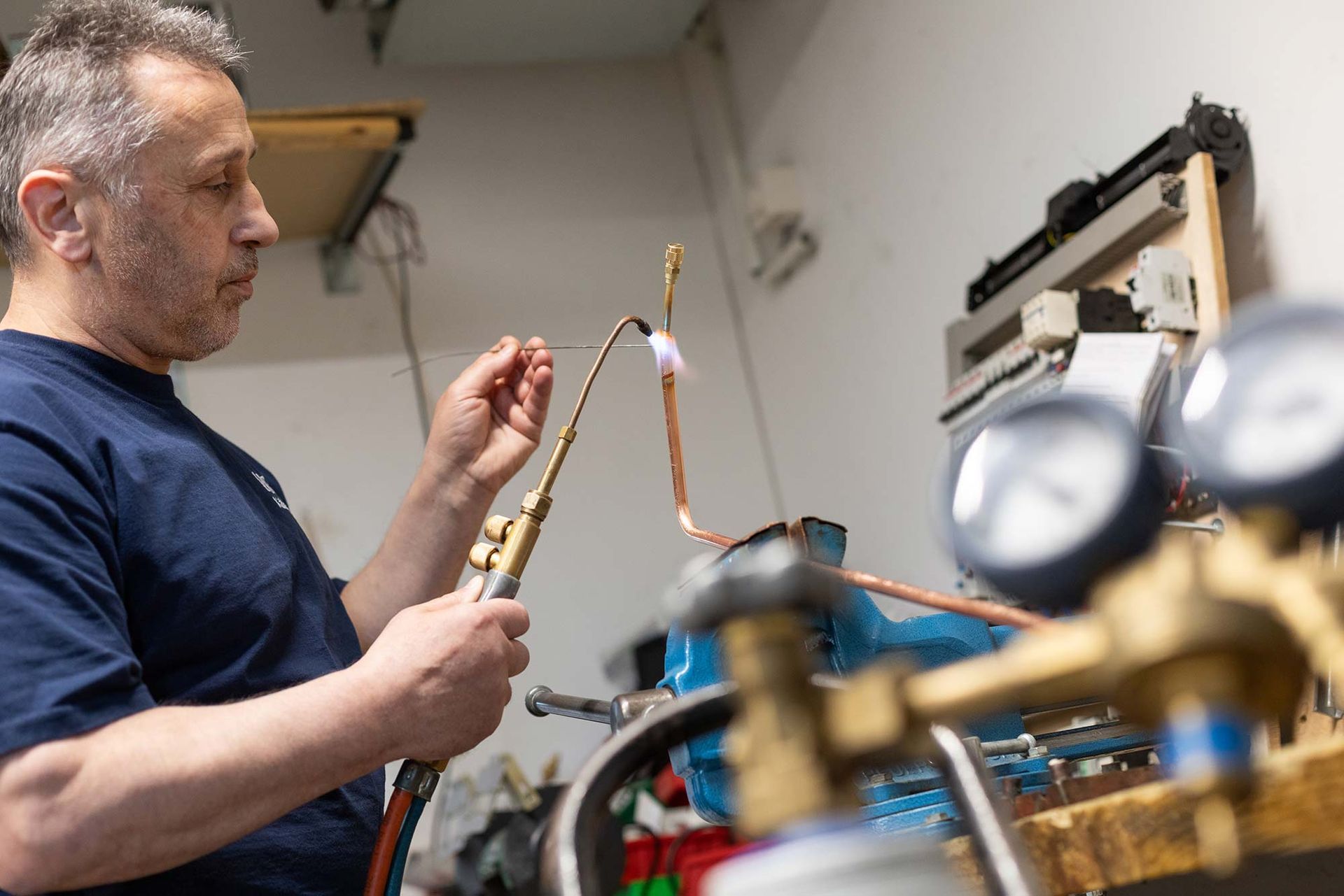 Ein Mann arbeitet in einer Garage an einem Gerät.