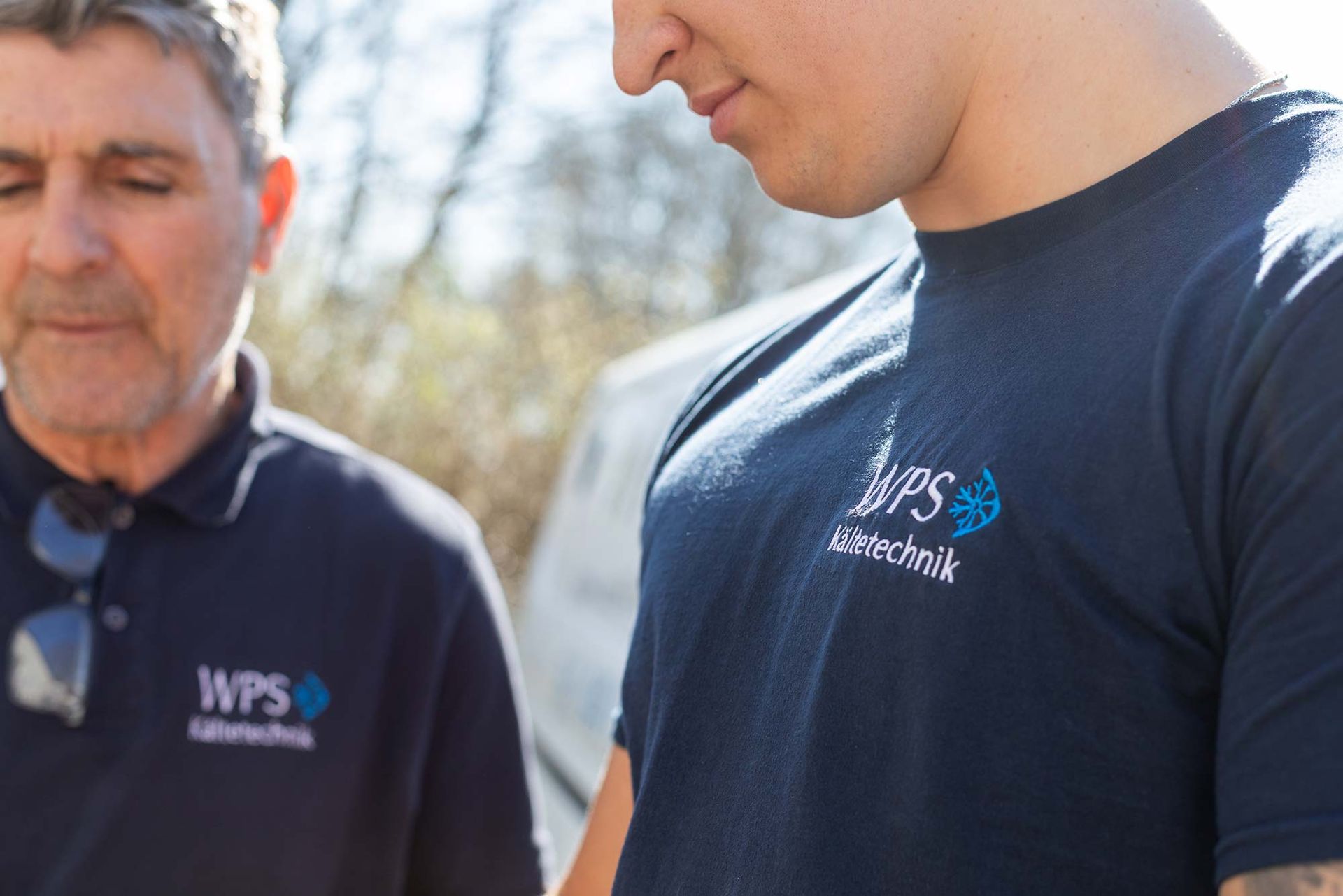 Zwei Männer in WPS-Shirts stehen nebeneinander.