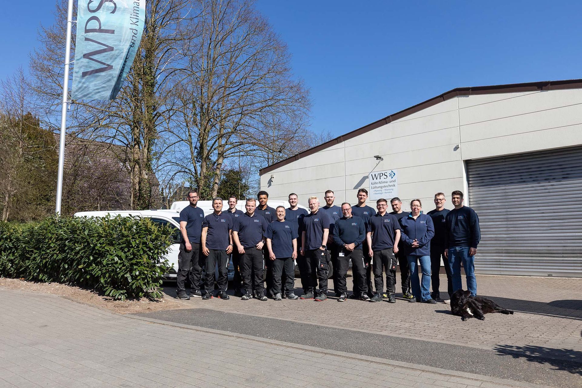 Eine Gruppe Männer posiert vor einem Gebäude für ein Foto.