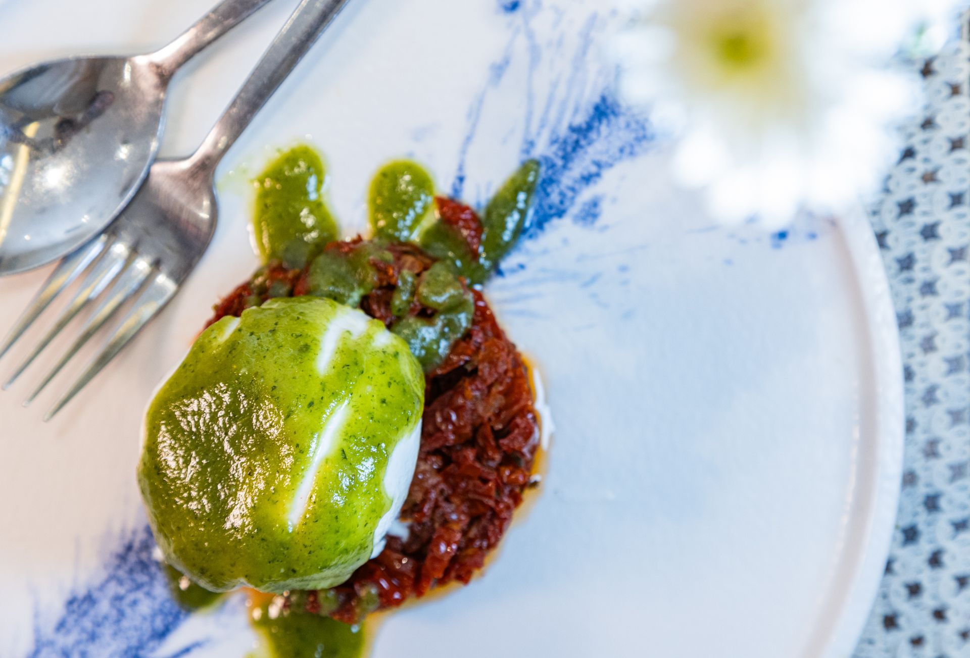 Una persona sostiene un plato de comida con un huevo encima.