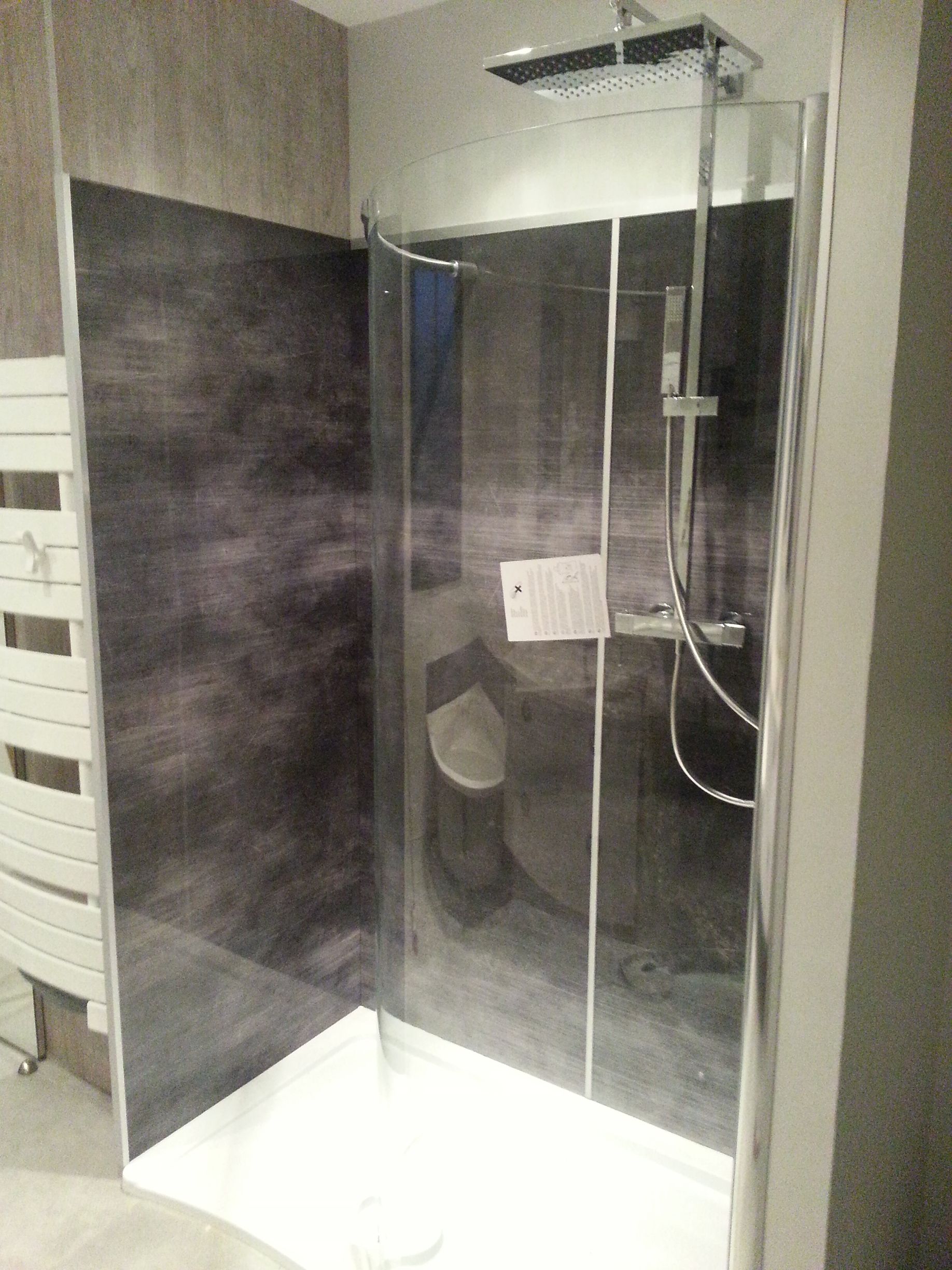 Douche à l'italienne moderne avec paroi de verre, carrelage mural foncé et receveur blanc dans une salle de bains.