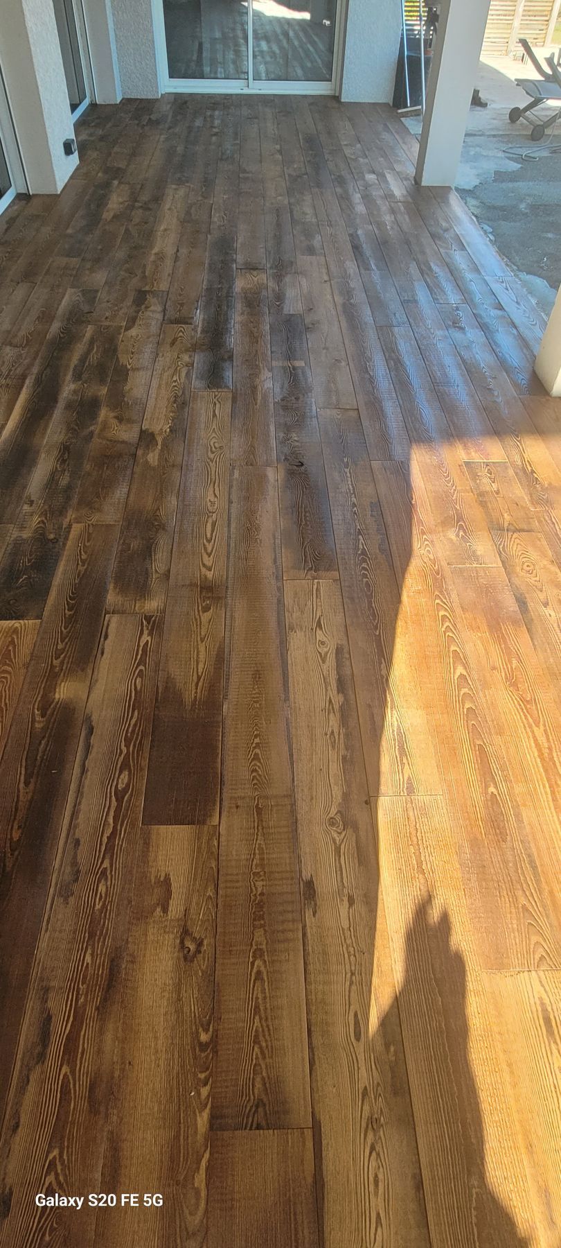 Parquet ensoleillé aux tons de bois foncés et dorés dans un couloir ou un salon
