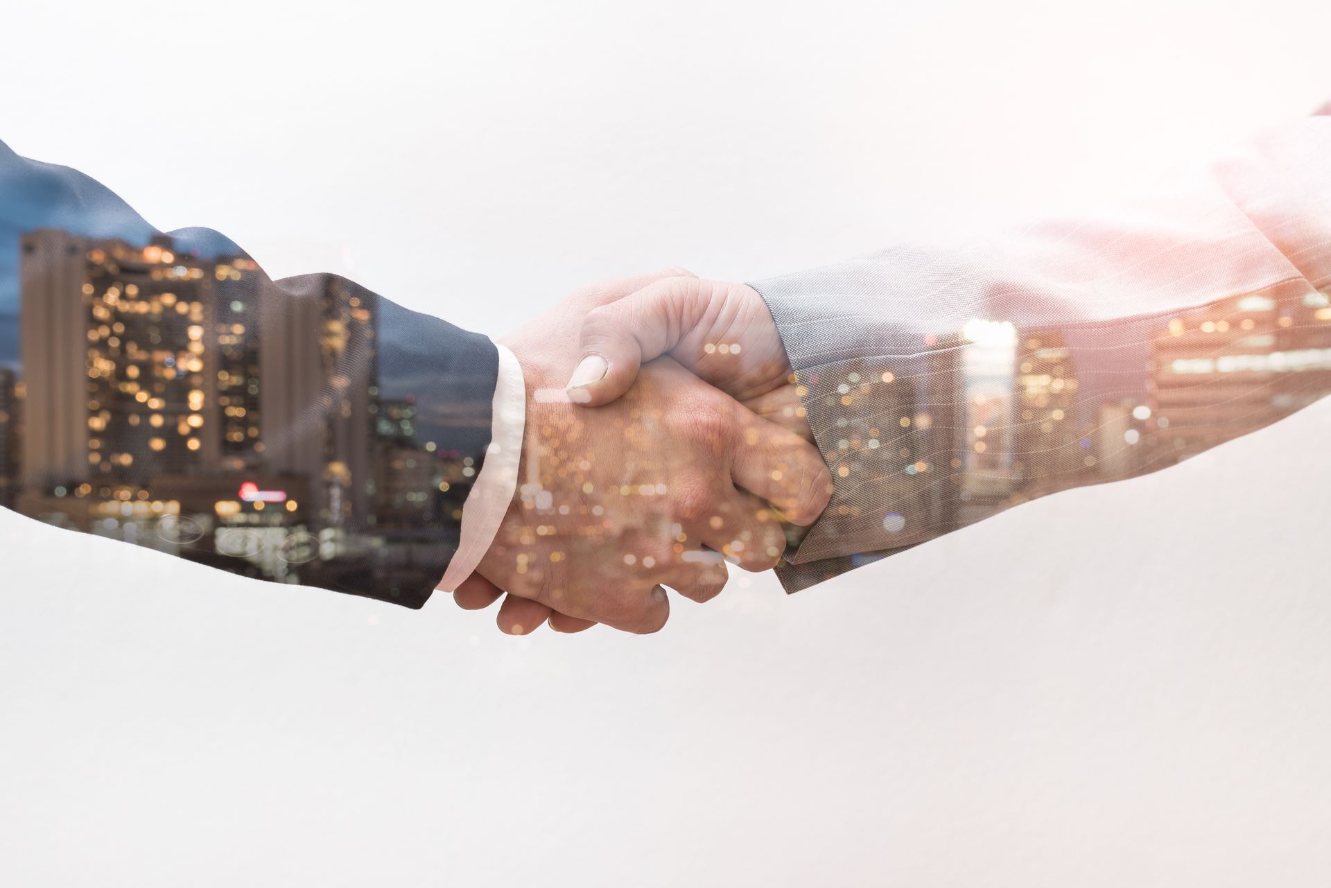 Une poignée de main mêlant silhouette urbaine et imagerie d'entreprise, symbolisant le partenariat et la croissance