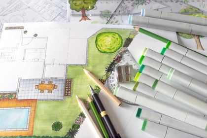 Eine Gartenzeichnung mit Markern und Bleistiften auf einem Tisch.